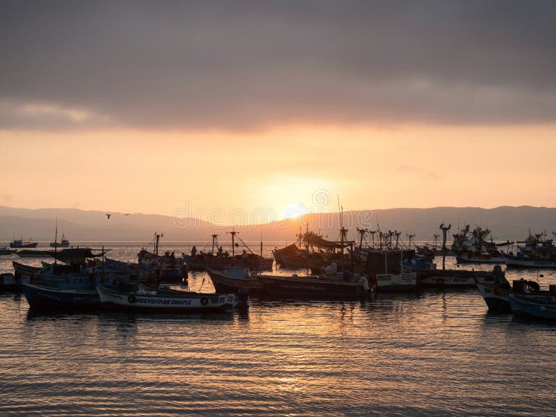 Maritime sunset seascape of traditional typical fishing boat ships Paracas harbor port pacific ocean Peru South America