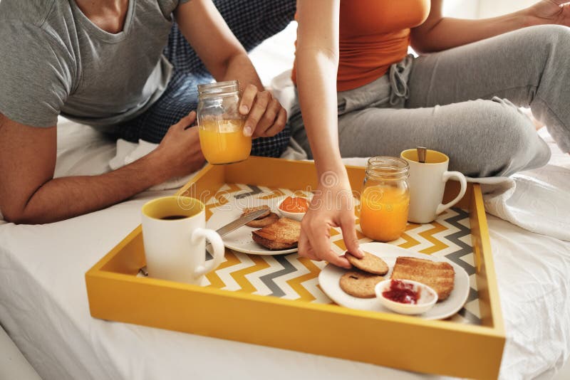 Marito felice e moglie che mangiano prima colazione a letto immagini stock libere da diritti Marito felice e moglie che mangiano prima colazione a letto immagini stock libere da diritti