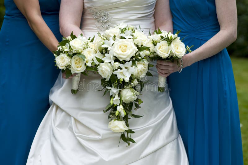 Mariée et demoiselles d'honneur retenant des bouquets de mariage image stock Mariée et demoiselles d'honneur retenant des bouquets de mariage image stock