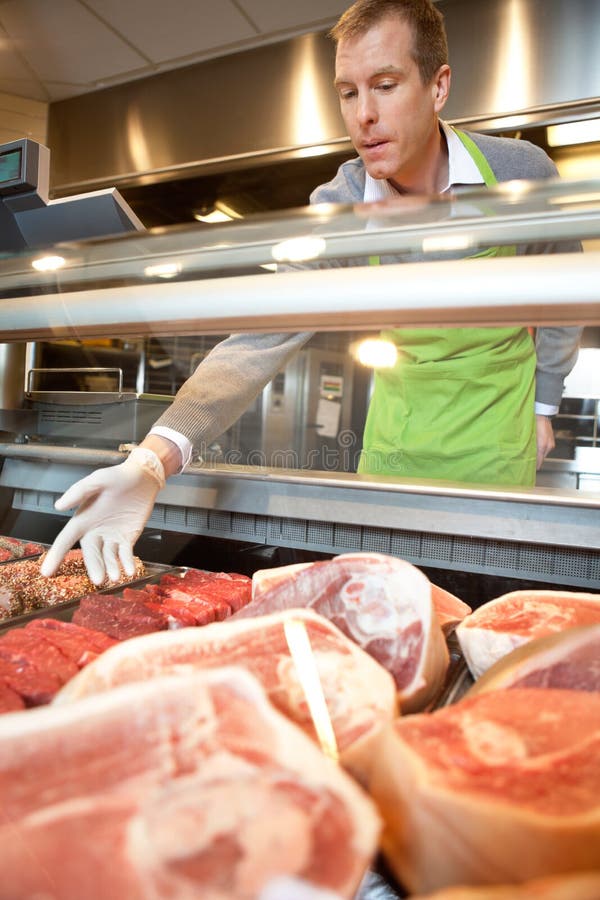 Market assistant picking meat royalty free stock image