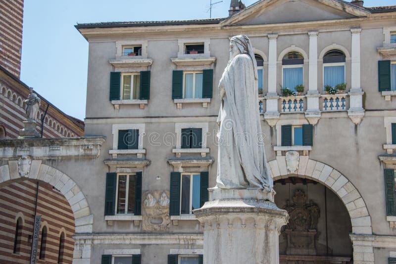 Dante Alighieri marble monument in the center of the city Verona, northern Italy. A civilian part of the town with trees and benches, blue sky. Dante Alighieri marble monument in the center of the city Verona, northern Italy. A civilian part of the town with trees and benches, blue sky.