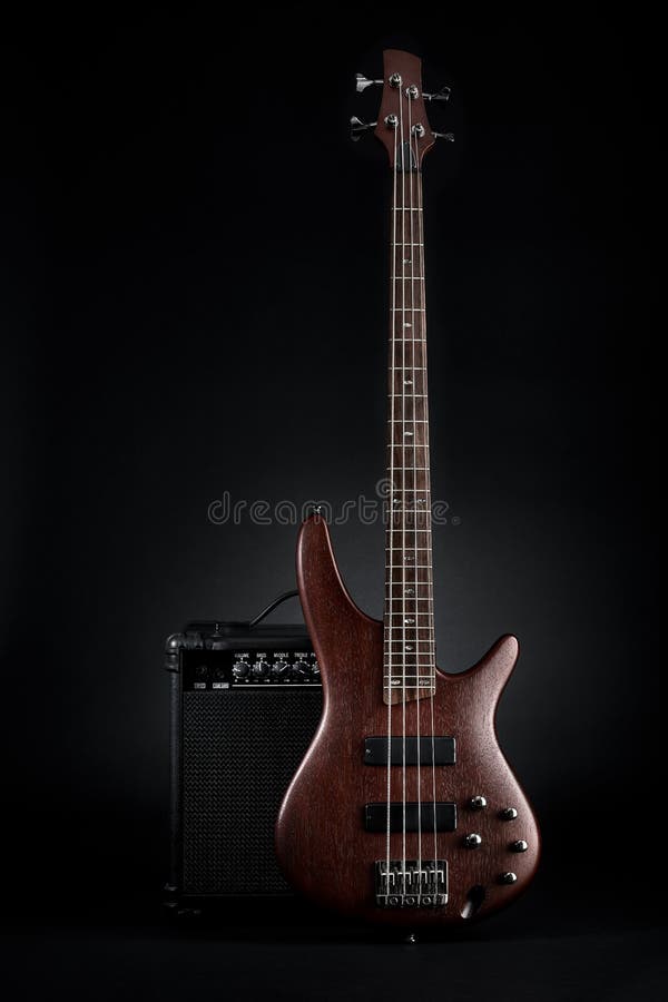 Maroon bass guitar and black amplifier stock images