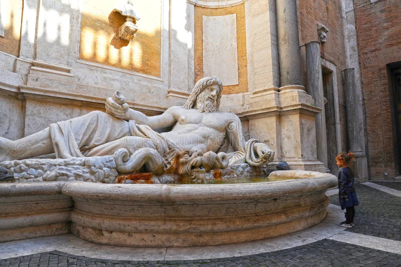 Marphurius oder Marforio, die Statuen von Rom mit einem Baby aufpasst es sprechen, ist Sch?ne alte Fenster in Rom (Italien) lizenzfreies stockbild Marphurius oder Marforio, die Statuen von Rom mit einem Baby aufpasst es sprechen, ist Sch?ne alte Fenster in Rom (Italien) lizenzfreies stockbild