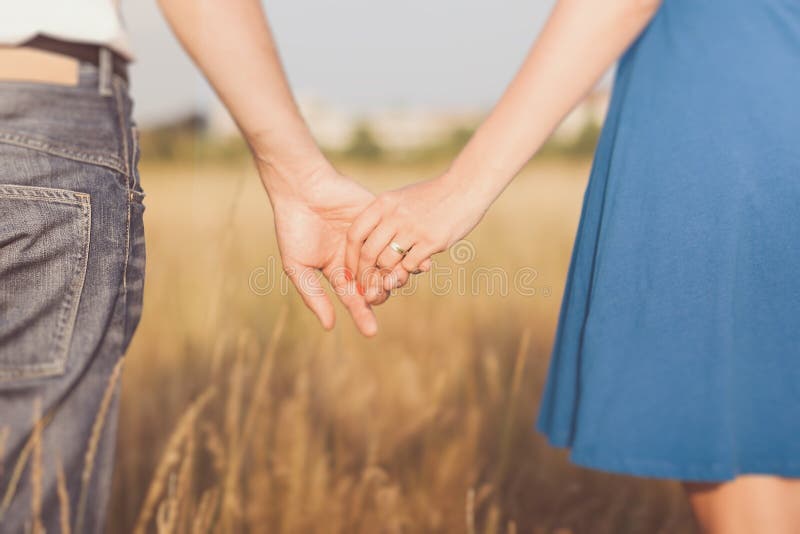 Married couple holding hands at sunset