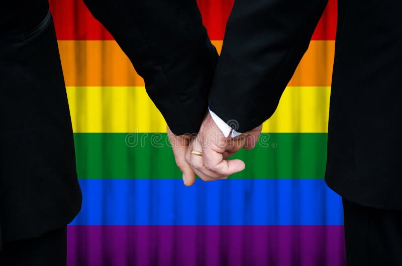 Married with Pride - two gay men stand hand in hand before a marriage altar featuring an overlay of pride flag colors, having just been legally married under Same-Sex Marriage legislation.