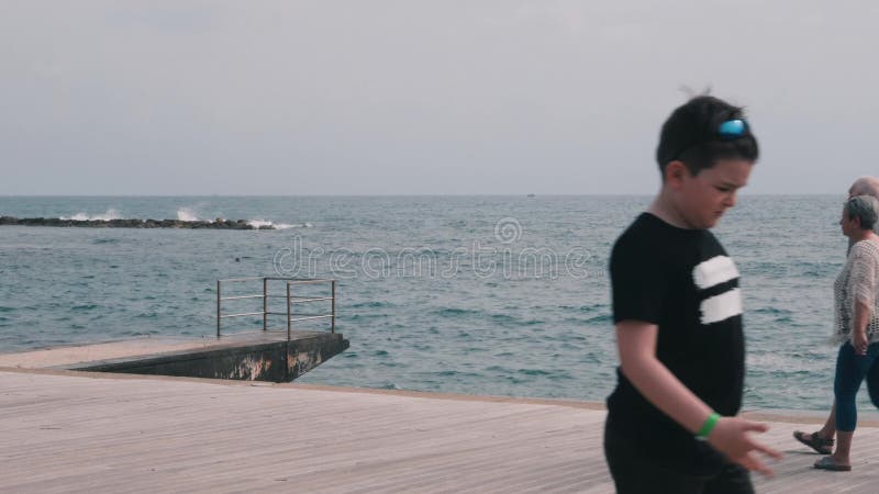 16 mars 2019/Chypre, Paphos. PiÃ¨ce de tourisme avec personnes marchant le long de la plage de mer. Vieux couple agrÃ©able en flÃ¢