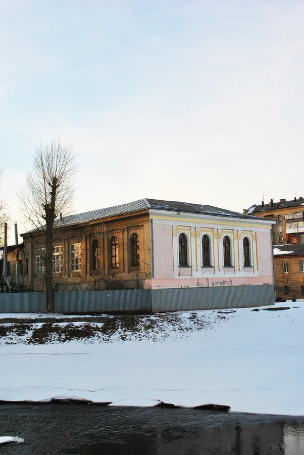 Mars 2018 : Paysage de ville, vieille maison sur le remblai de rivière, arbre sans feuilles, barrière autour, fondant la glace su photo libre de droits Mars 2018 : Paysage de ville, vieille maison sur le remblai de rivière, arbre sans feuilles, barrière autour, fondant la glace su photo libre de droits