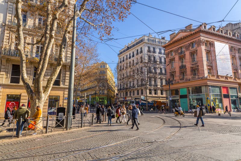 Typical French Buildings And People Walking At La Canebiere In