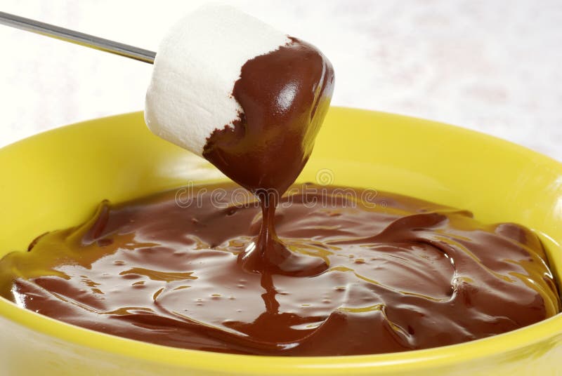Marshmallow macro mergulhado no chocolate do fondue imagens de stock royalty free Marshmallow macro mergulhado no chocolate do fondue imagens de stock royalty free