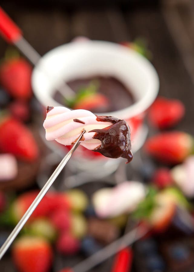 Marshmallow mergulhado no fondue de chocolate imagem de stock Marshmallow mergulhado no fondue de chocolate imagem de stock