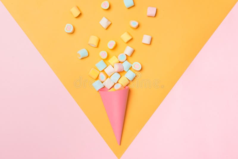 Marshmallow ζωηρόχρωμη κατάταξη καραμελών σε έναν κώνο παγωτού στο ρόδινο και κίτρινο υπόβαθρο που αντιμετωπίζεται άνωθεν Gummy π στοκ εικόνες Marshmallow ζωηρόχρωμη κατάταξη καραμελών σε έναν κώνο παγωτού στο ρόδινο και κίτρινο υπόβαθρο που αντιμετωπίζεται άνωθεν Gummy π στοκ εικόνες