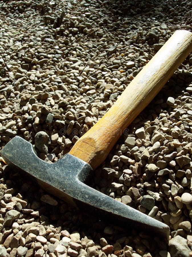 A chisel hammer lies in gravel after a hard days work. A chisel hammer lies in gravel after a hard days work