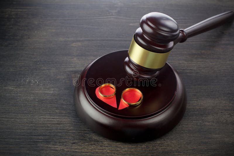 Wedding rings hammer of a judge on a wooden background. Divorce proceedings. Wedding rings hammer of a judge on a wooden background. Divorce proceedings
