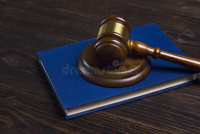 Martelo de madeira dos juizes que encontra-se no livro legal na tabela de madeira fotografia de stock royalty free Martelo de madeira dos juizes que encontra-se no livro legal na tabela de madeira fotografia de stock royalty free