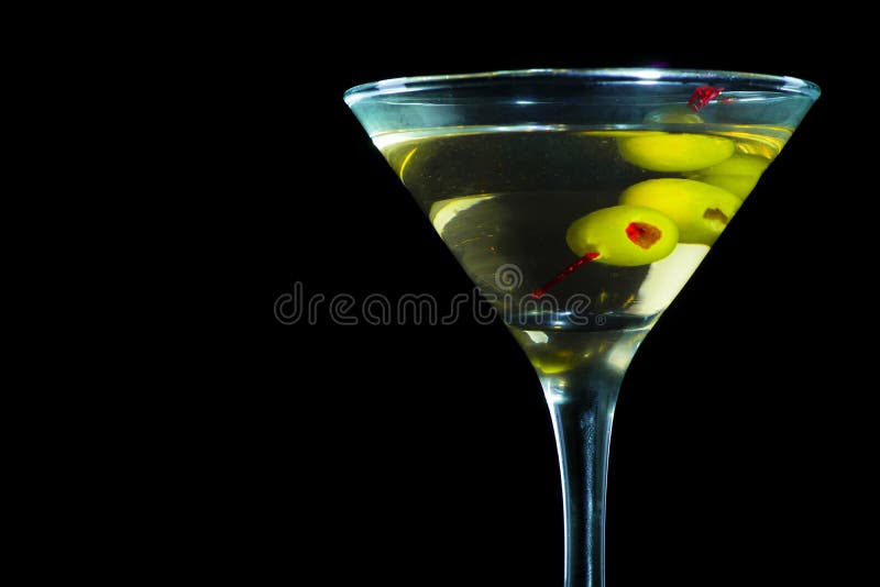 A Martini Glass with Green Olives on a Black Background Stock Photo