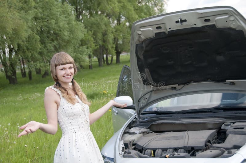 Worried young woman near her broken car with non-urban background. Worried young woman near her broken car with non-urban background