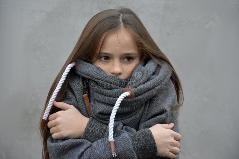 Marznięcie dziewczyny snuggles w jej woolen pulowerze fotografia stock Marznięcie dziewczyny snuggles w jej woolen pulowerze fotografia stock