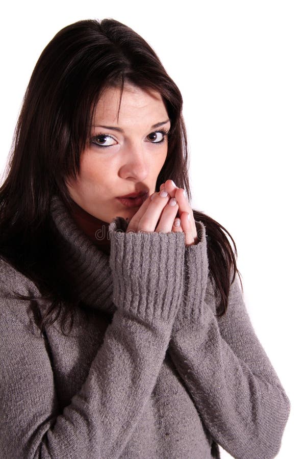 A womanblows in her hand to warm them up. All isolated on white background. A womanblows in her hand to warm them up. All isolated on white background.