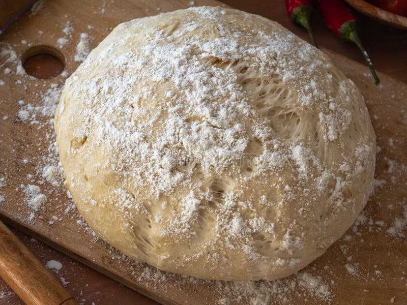 Masa de levadura de pizza en una tabla de picar fotografía de archivo