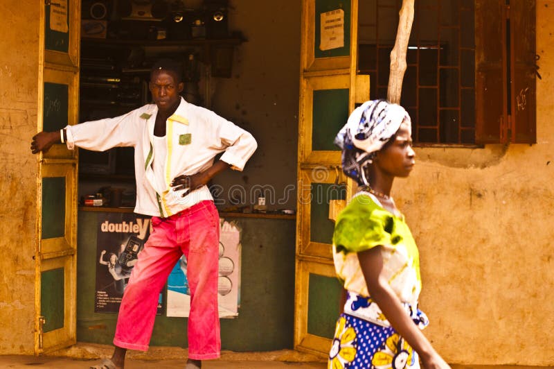 MASAI MARA, KENYA. DECEMBER 18, 2011: A Kenyan man in pink trousers stands in the doorway of his shop in Mombassa. MASAI MARA, KENYA. DECEMBER 18, 2011: A Kenyan man in pink trousers stands in the doorway of his shop in Mombassa.