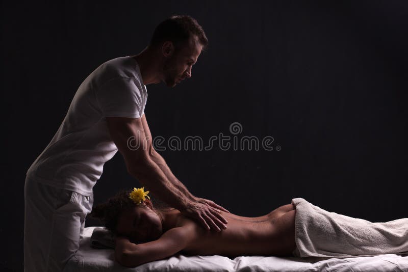 Masajista hermoso que hace el masaje para la mujer morena foto de archivo Masajista hermoso que hace el masaje para la mujer morena foto de archivo