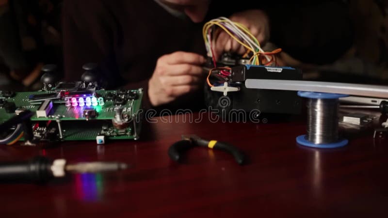 Maschine elektronisch steuern. home experimente robotik smart ingenieur. Kinderspielzeug. ein Mann sammelt Reparaturen an einem stock video