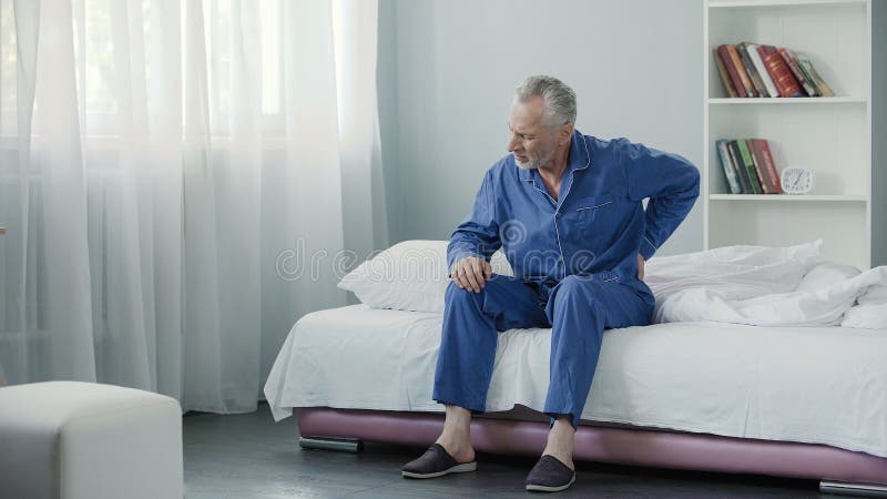 Senior male suffering sharp back pain, sick person getting up from bed, morning, stock footage. Senior male suffering sharp back pain, sick person getting up from bed, morning, stock footage