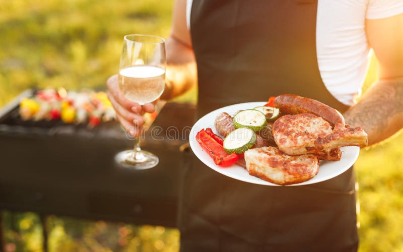 Masculi cu fața la grătar și vin stock photography