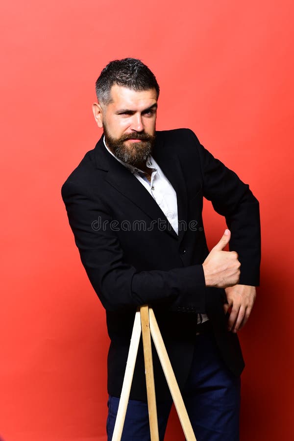 Masculinity and style concept. Macho man leans on tripod stock photography Masculinity and style concept. Macho man leans on tripod stock photography