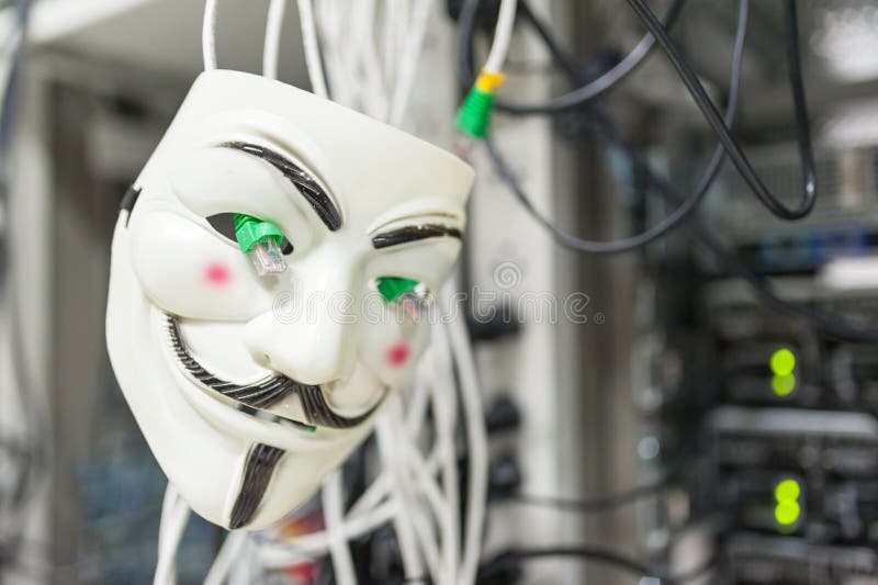 Masked Hacker in Computer Server room Concept. royalty free stock photography
