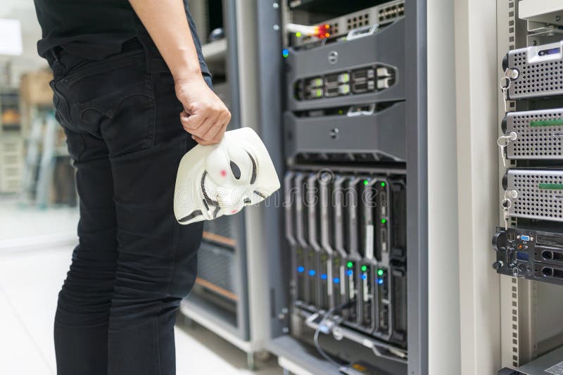 Masked Hacker in Computer Server room Concept. stock image