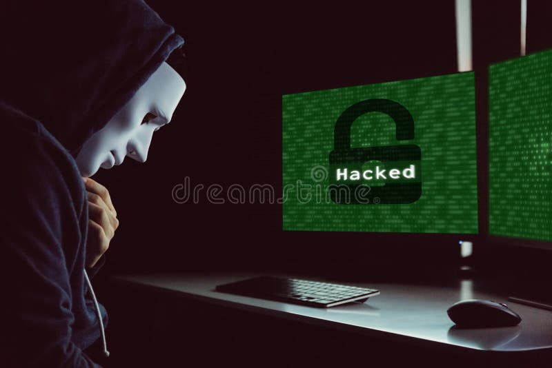 Masked hacker under hood using computer to hack into system and trying to commit computer crime. Masked hacker under hood using computer to hack into system and stock photos Masked hacker under hood using computer to hack into system and trying to commit computer crime. Masked hacker under hood using computer to hack into system and stock photos