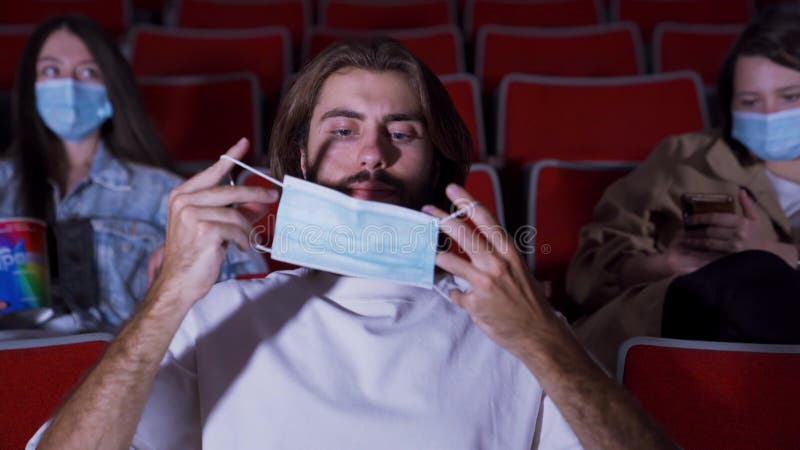 Masked man in movie theater. Media. People in movie theaters must wear protective masks. Man is given medical mask in