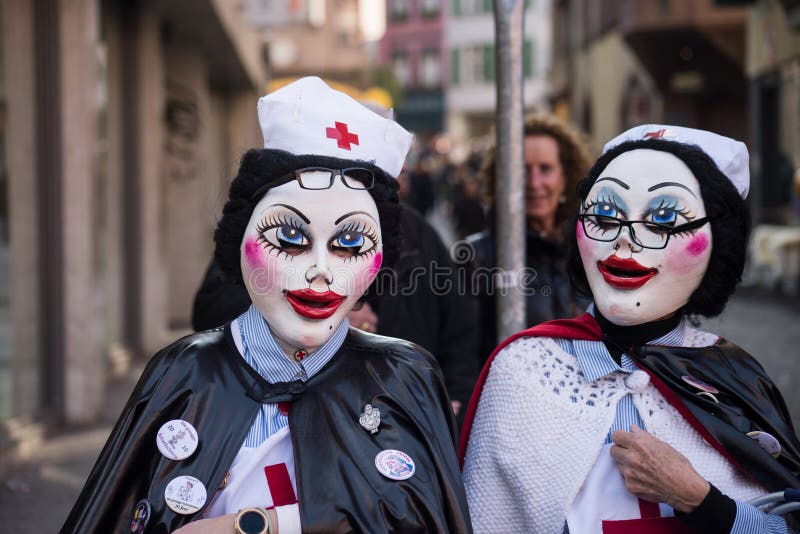 Basel - Switzerland - 9 March 2022 - Portrait of masked women wearing nurs costue parading in the street. Basel - Switzerland - 9 March 2022 - Portrait of masked women wearing nurs costue parading in the street