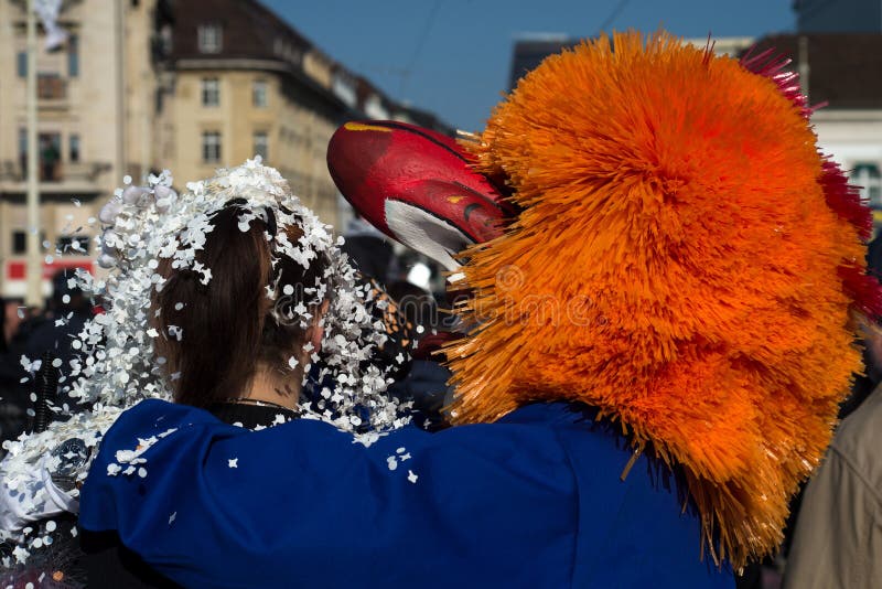 Basel - Switzerland - 9 March 2022 - portrait of masked people playing with confetti in the street. Basel - Switzerland - 9 March 2022 - portrait of masked people playing with confetti in the street