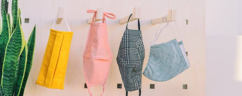 Fabric face masks hanging on closet hooks. Many colors and patterns to make your own mask at home for corona virus prevention. Panoramic banner. Fabric face masks hanging on closet hooks. Many colors and patterns to make your own mask at home for corona virus prevention. Panoramic banner