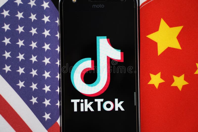 Maski, India 04, August 2020 - TikTok app logo on a smartphone screen in between China and United States - The app is in centre of US - China trade tensions and security concerns