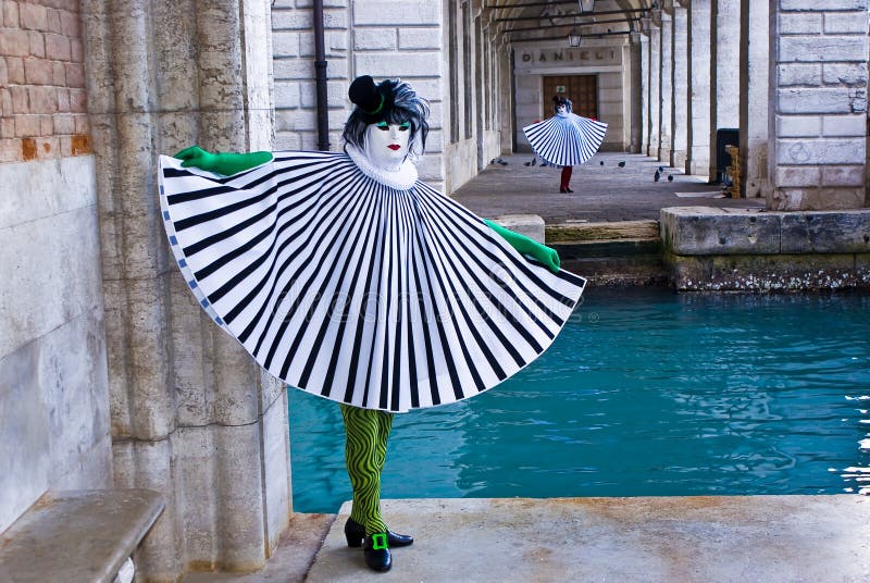 A pair of masks near a channel in the Venice lagoon, Italy. A pair of masks near a channel in the Venice lagoon, Italy