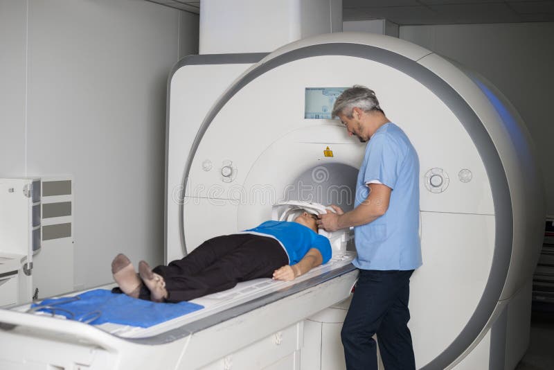 Maskin för bildläsning för CT för kvinnlig patient för doktor Fixing Mask To liggande royaltyfri fotografi Maskin för bildläsning för CT för kvinnlig patient för doktor Fixing Mask To liggande royaltyfri fotografi