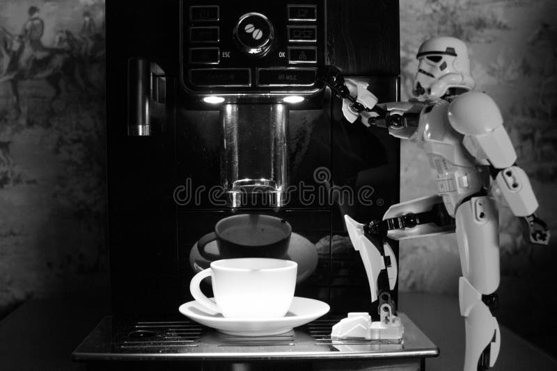 Maskin för svart kaffe och en vit leksakrobot royaltyfria bilder