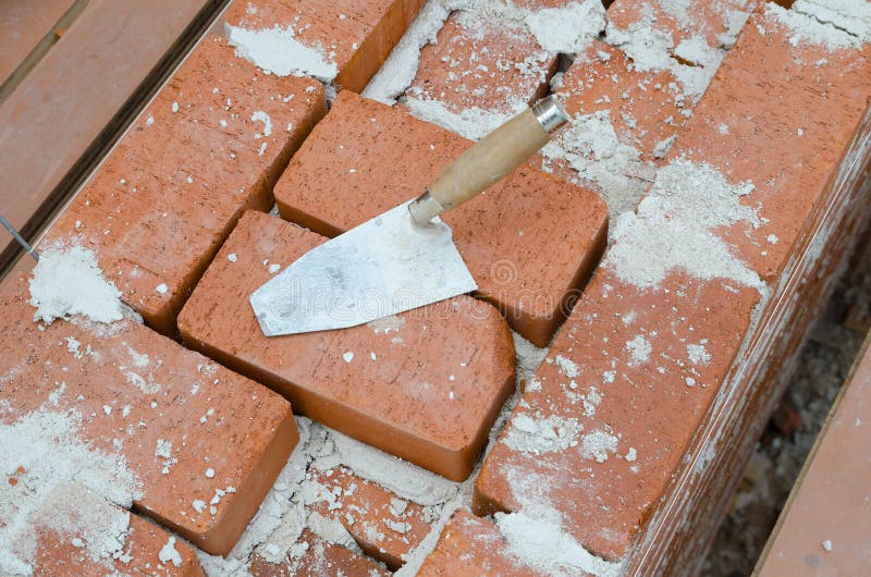 Mason Bricklaying Background with Trowel and Brick Blocks Stock Photo