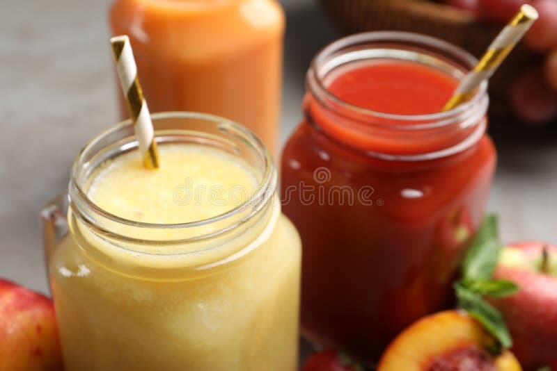 Mason-burkar med utsökt juicer med halmstängsel arkivfoto
