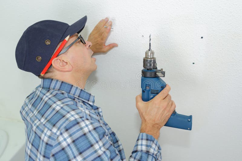 Mason drilling into wall stock photo. Image of experienced 99537964