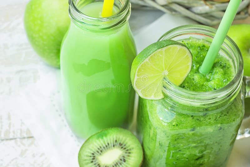 Mason Jar e garrafa de vidro com vegetal e batido de fruta e suco verdes com palha Cesta com produto orgânico sazonal imagens de stock Mason Jar e garrafa de vidro com vegetal e batido de fruta e suco verdes com palha Cesta com produto orgânico sazonal imagens de stock