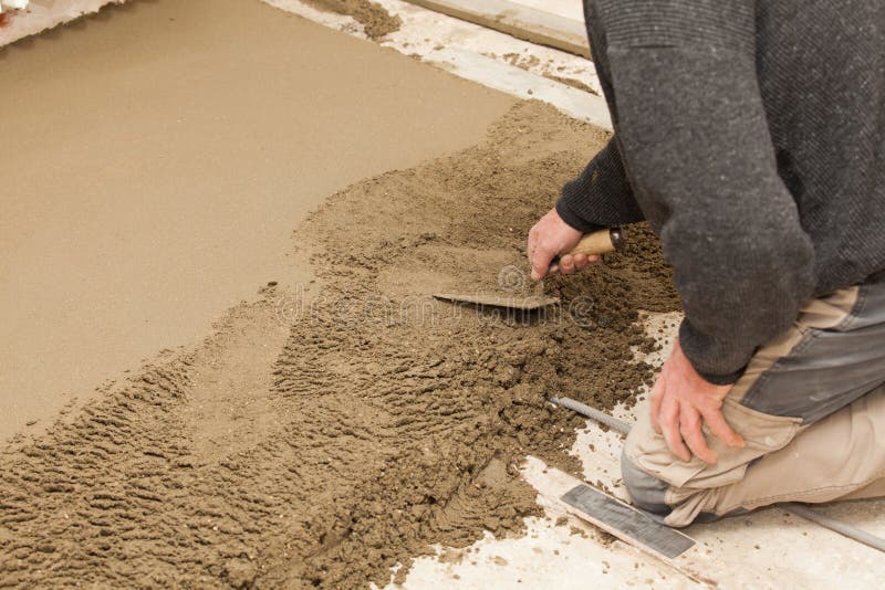 Mason leveling the cement screed stock images