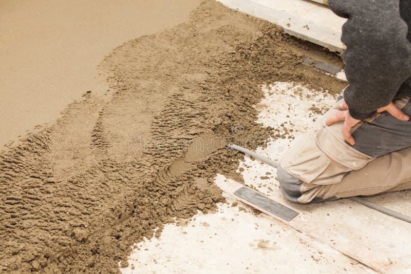 Mason leveling the cement screed stock images
