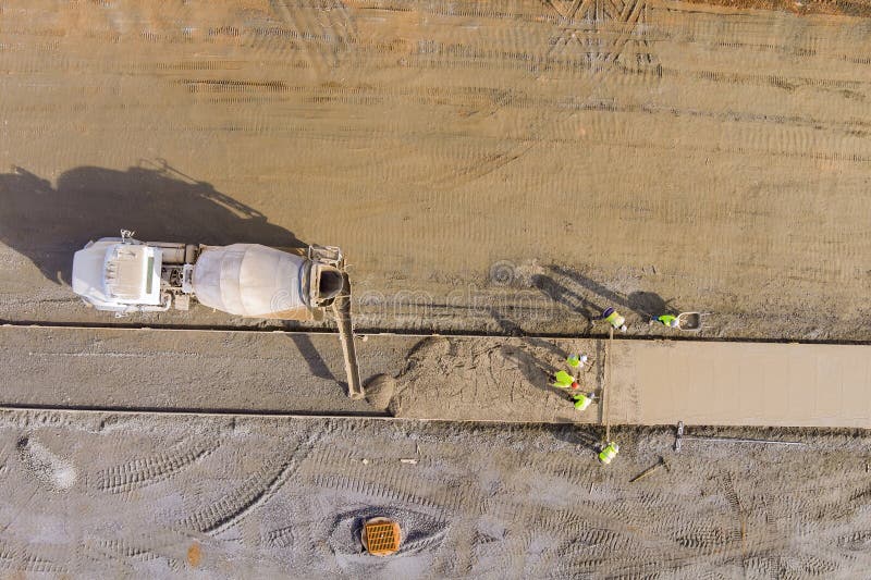 Mason workers introduce concrete pouring process from mixer truck for a footpath sidewalk stock photos