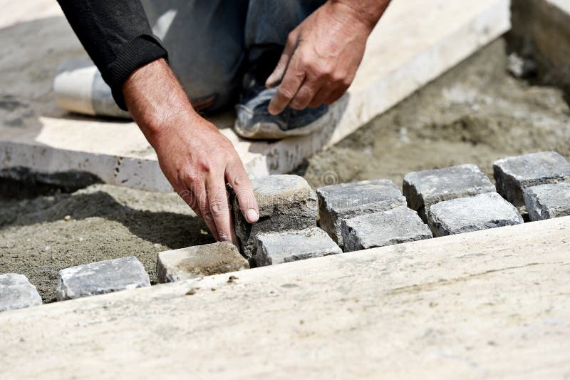 Details with hands of a mason working with cobblestone. Bricklayer tiler stock images, royalty-free photos and pictures
