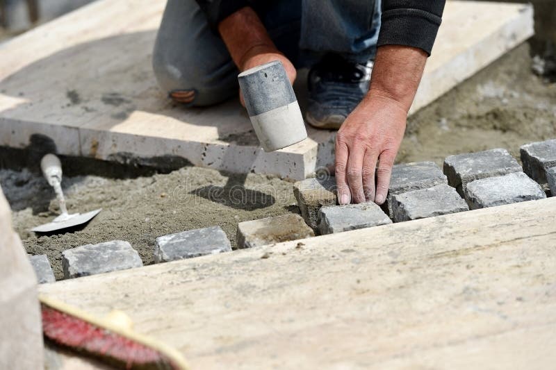 Details with hands of a mason working with cobblestone. Bricklayer tiler stock images, royalty-free photos and pictures