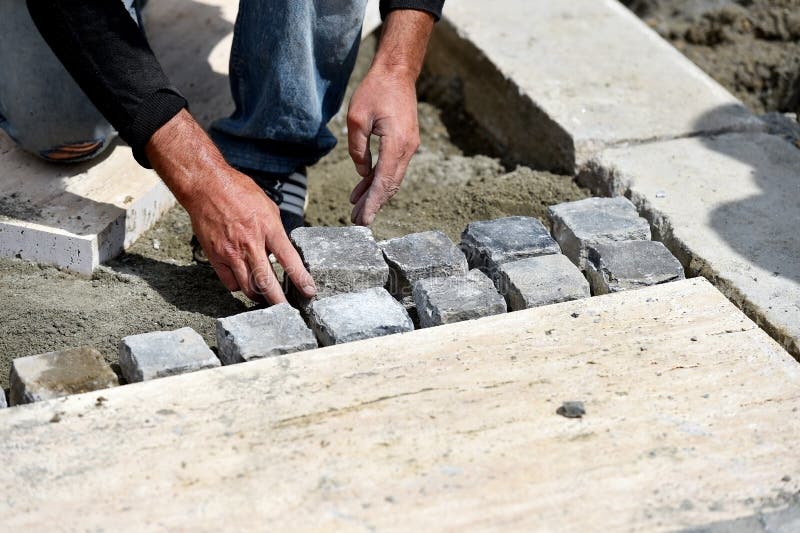 Details with hands of a mason working with cobblestone. Bricklayer tiler stock images, royalty-free photos and pictures